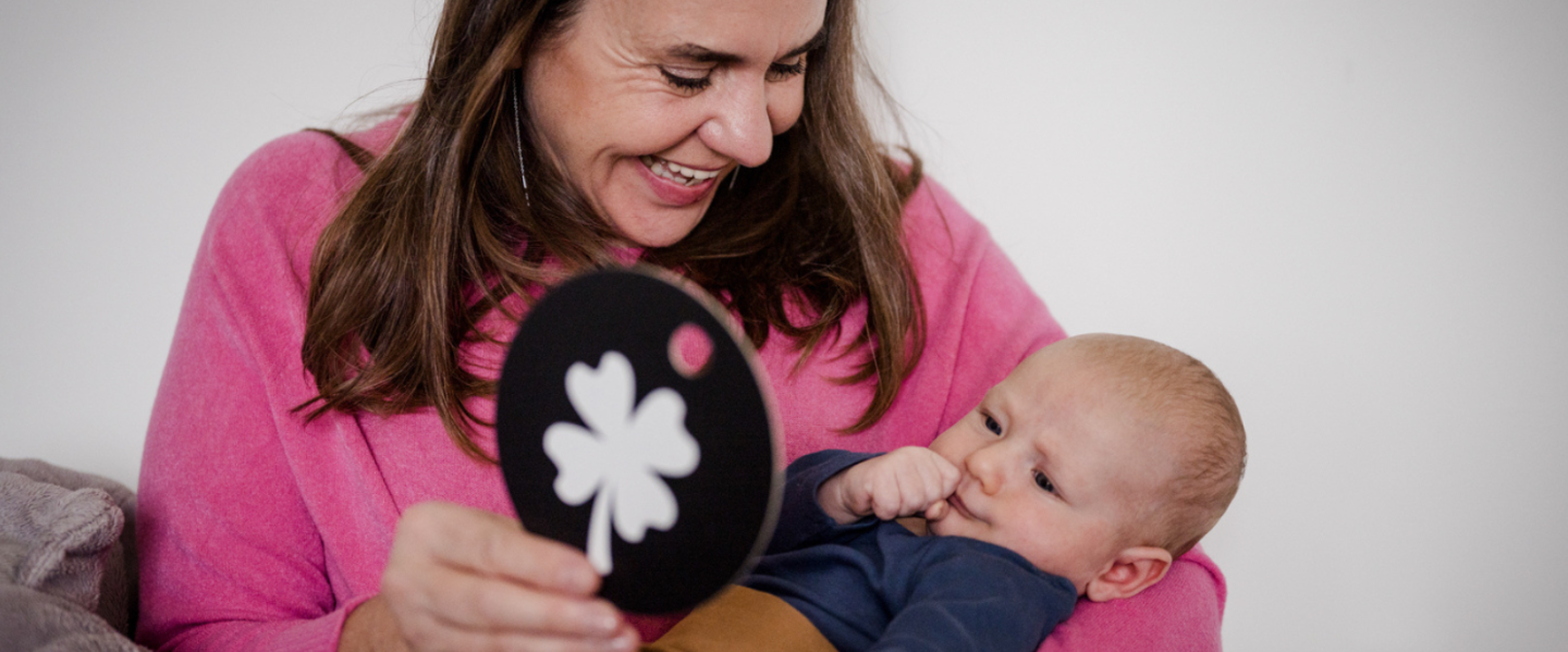 Oma und Baby schauen sich eine Kontrastkarte an